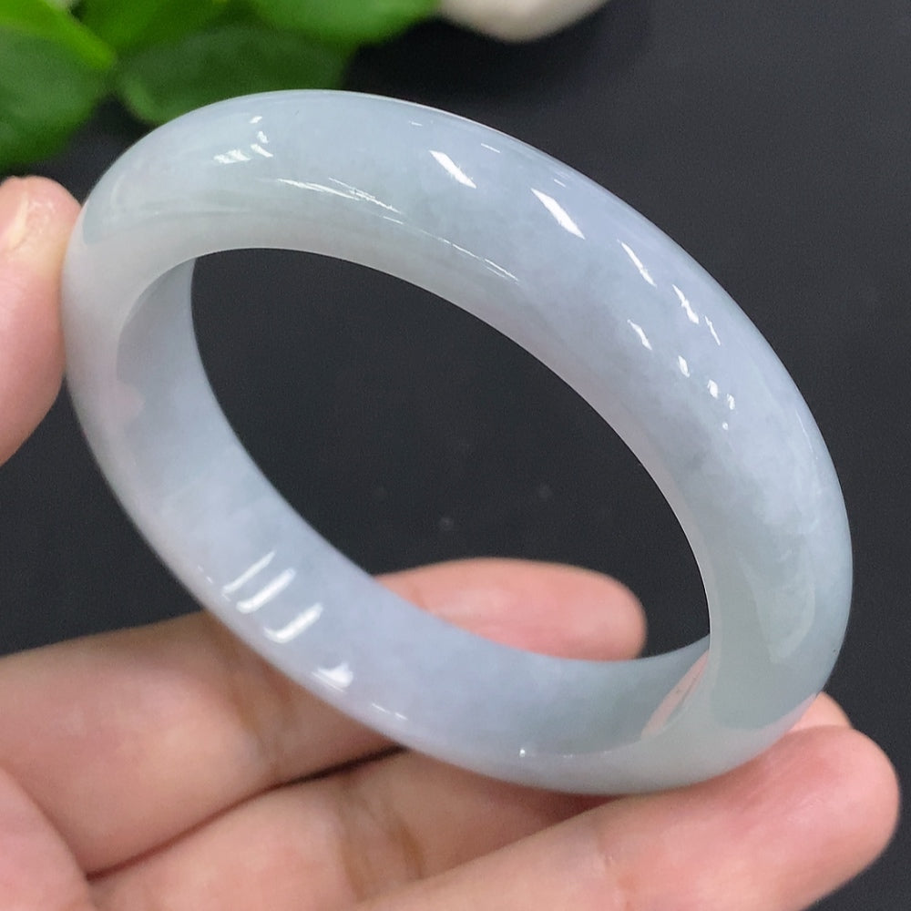 Huiliu certified jadeite round bangle showcasing smooth, polished green jade with intricate craftsmanship.