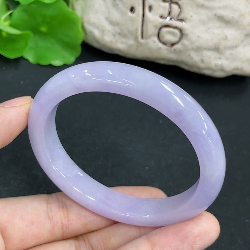 Close-up of a jadeite concubine bracelet featuring smooth, polished jadeite beads with intricate carvings, crafted by HKHQ.