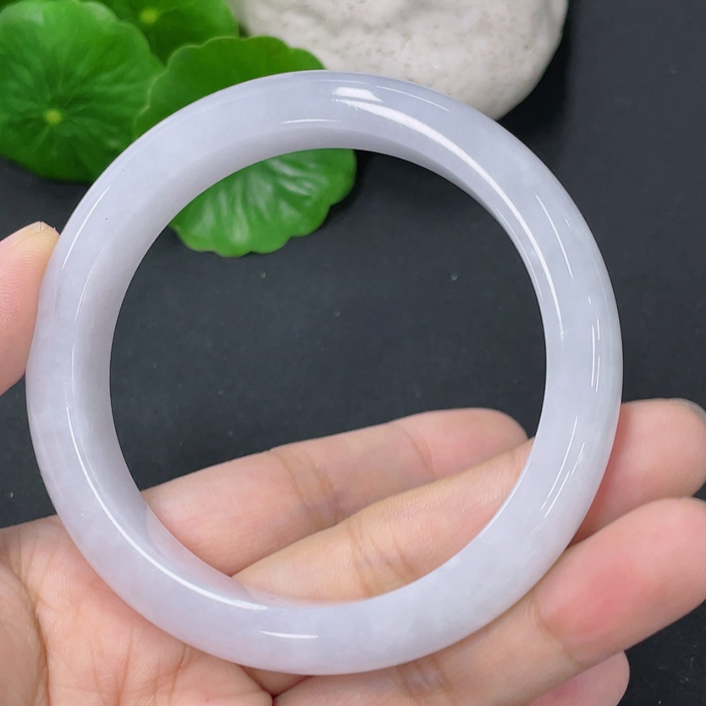 Huiliu Certified Jadeite round bangle showing smooth, polished green jade surface with subtle natural marbling and a glossy finish.