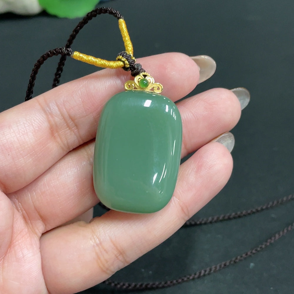 Huiliu certified Hetian jade pendant with plain design and rope, 71% jade content, showcasing smooth, polished surface and natural green hue.