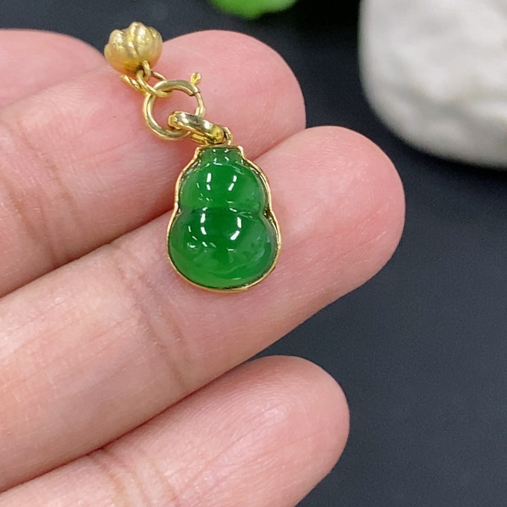 Jadeite gourd pendant with 18K gold inlay, crafted by HKHQ, featuring a smooth green jade surface and intricate gold detailing.