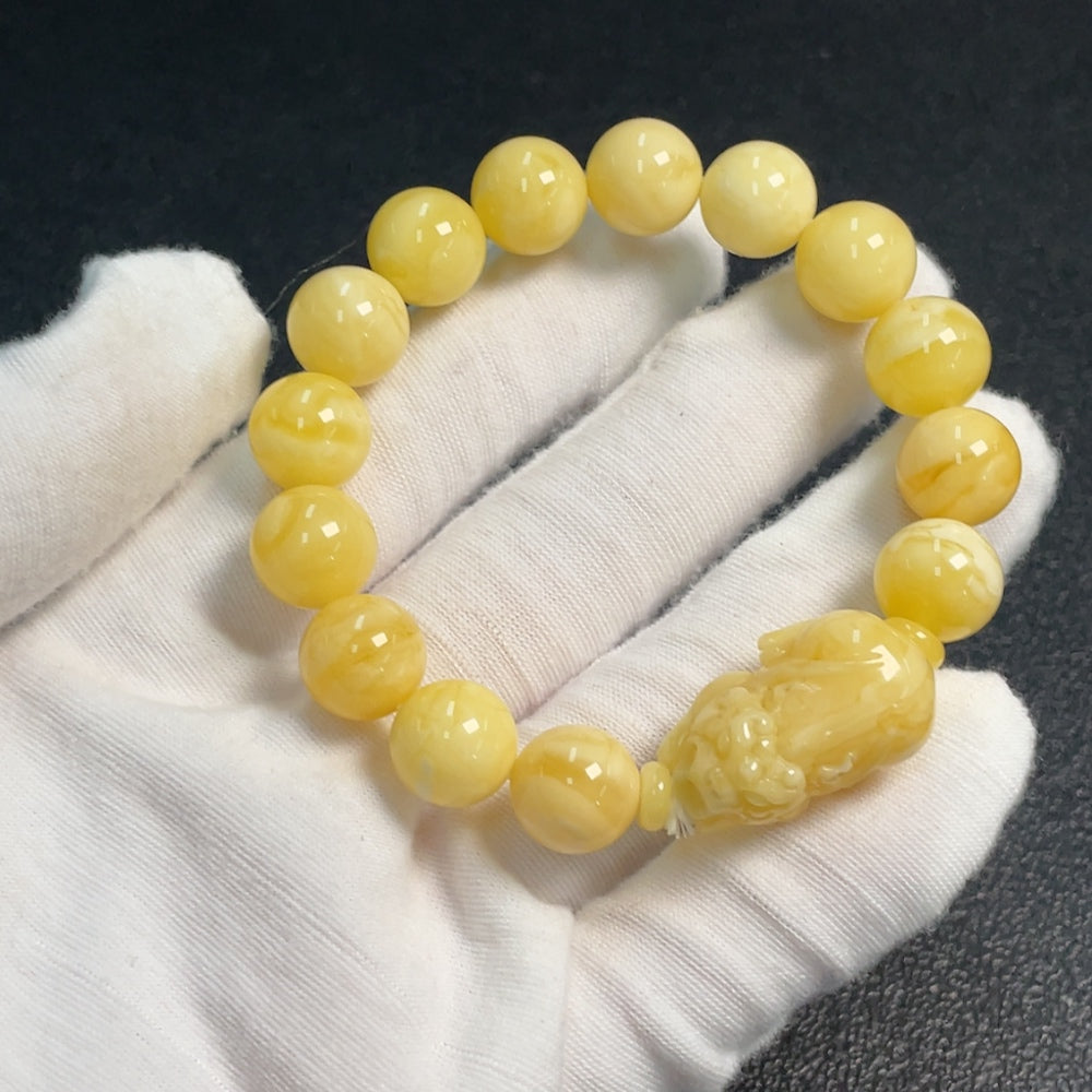 Amber and beeswax bracelet by HUILIU HQ featuring 11.1-14.2mm amber beads and beeswax accents, weighs approximately 14g.