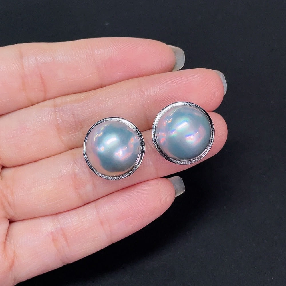 HKHQ composite saltwater pearl stud earrings with platinum and diamond accents, close-up of the elegant jewelry design