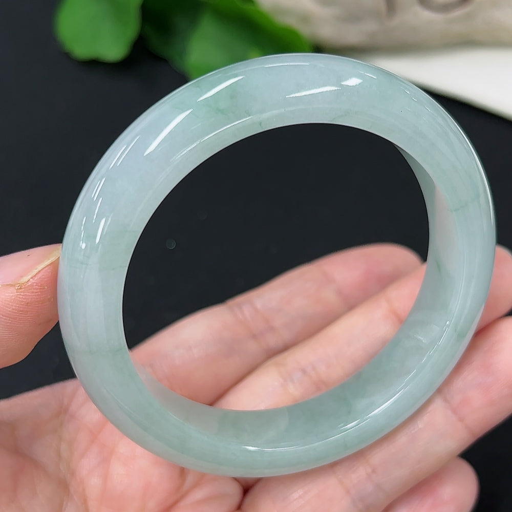 Jadeite round bangle with size 53.7 and weight 56.5g, crafted from green jade, displayed on a neutral background.