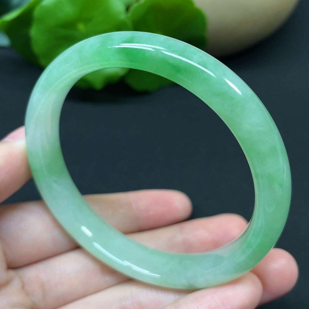 HKHQ jadeite round bangle, size 54.7, weighing 37.95g, showcasing smooth, polished jadeite jewelry on a plain background.