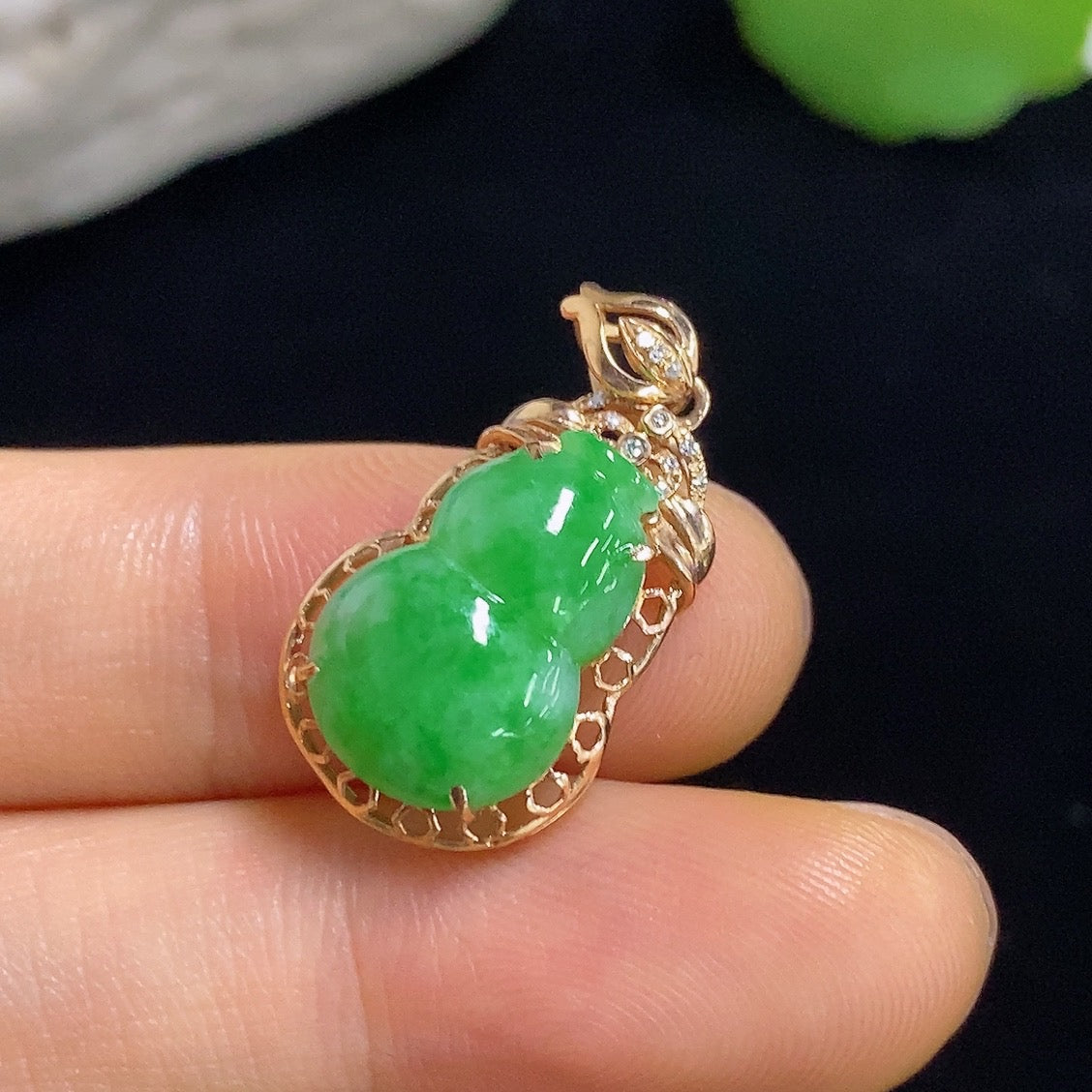 Jadeite gourd inlaid pendant with 18k gold and diamond accents, weighing approximately 1.93g, displayed on a jewelry stand.