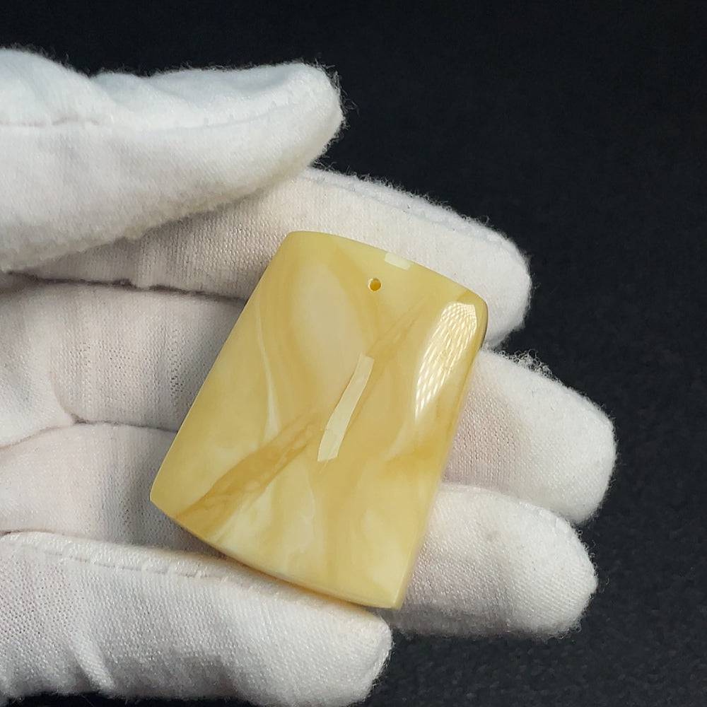 Amber beeswax pendant by HUILIU HQ, showcasing a natural amber pendant with warm golden tones and intricate organic details.