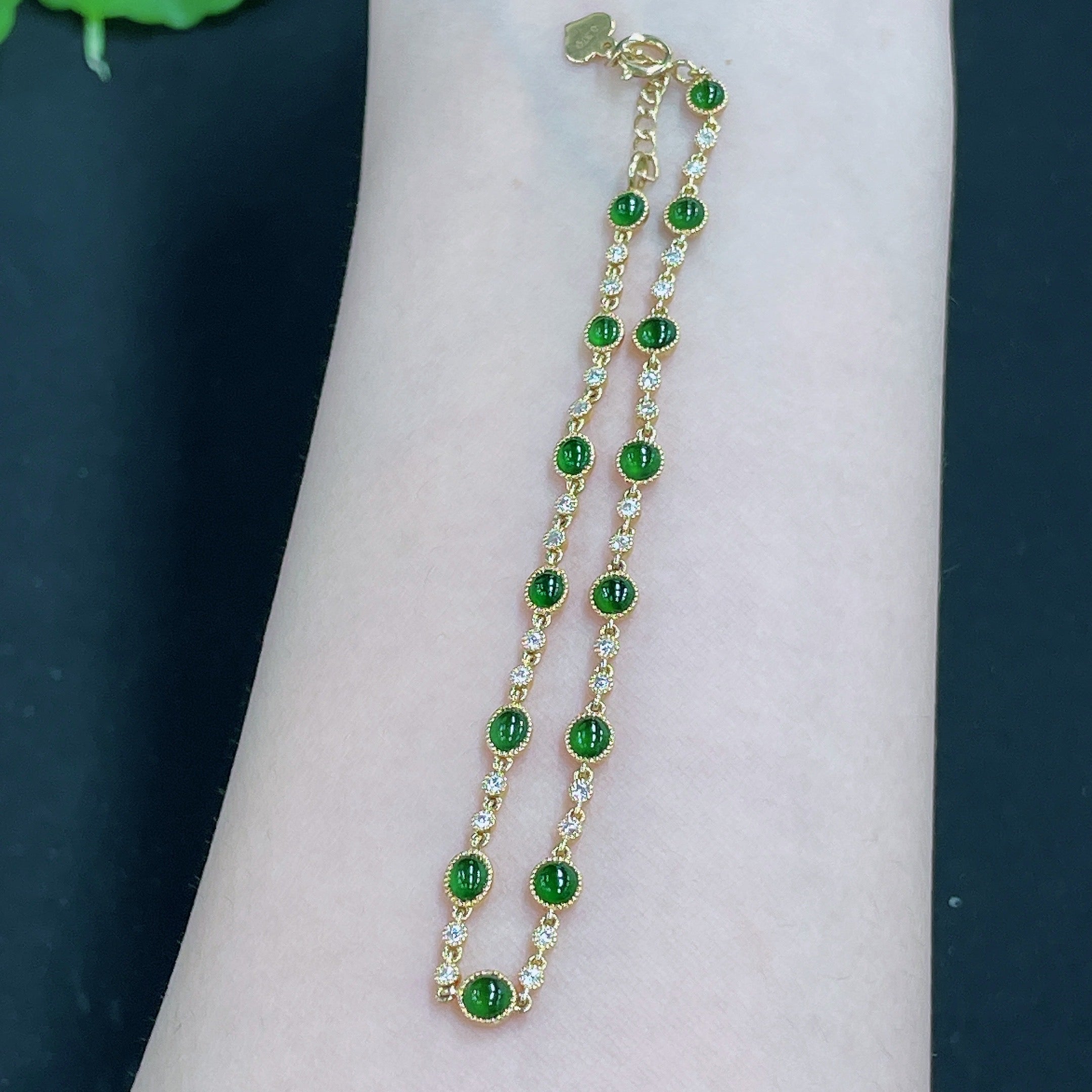 Jadeite cabochon inlaid bracelet with 18k gold and diamond accents, showcasing polished jade stones and intricate metalwork.