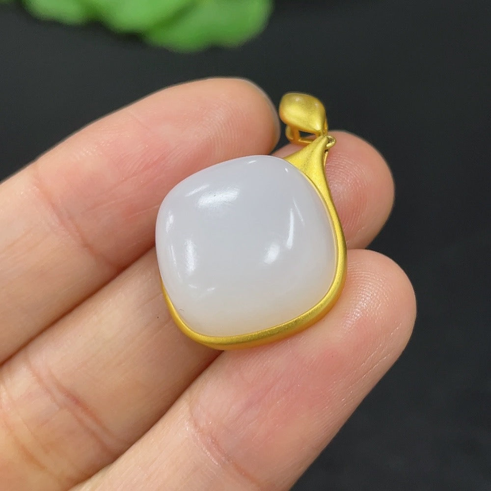 Hetian Jade inlaid pendant on 18K gold necklace, designed by HKHQ, showcasing a smooth jade stone with gold accents.