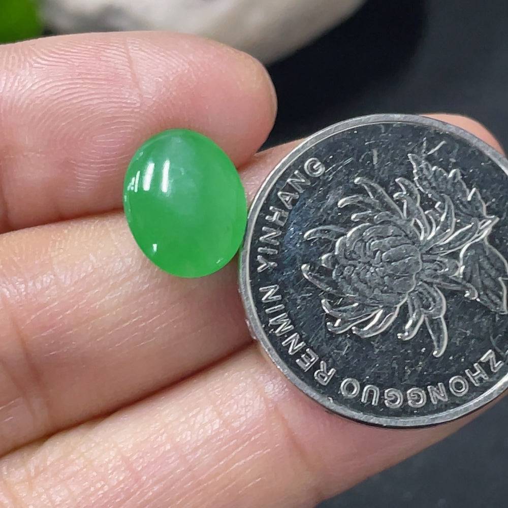 Jadeite cabochon from HUILIU HQ, approximately 0.67g, showcasing smooth, polished green jade with natural translucency.