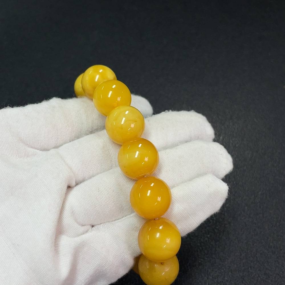 Amber beeswax bracelet with Hetian jade, featuring partial repair, showcasing natural amber beads and green jade accents.