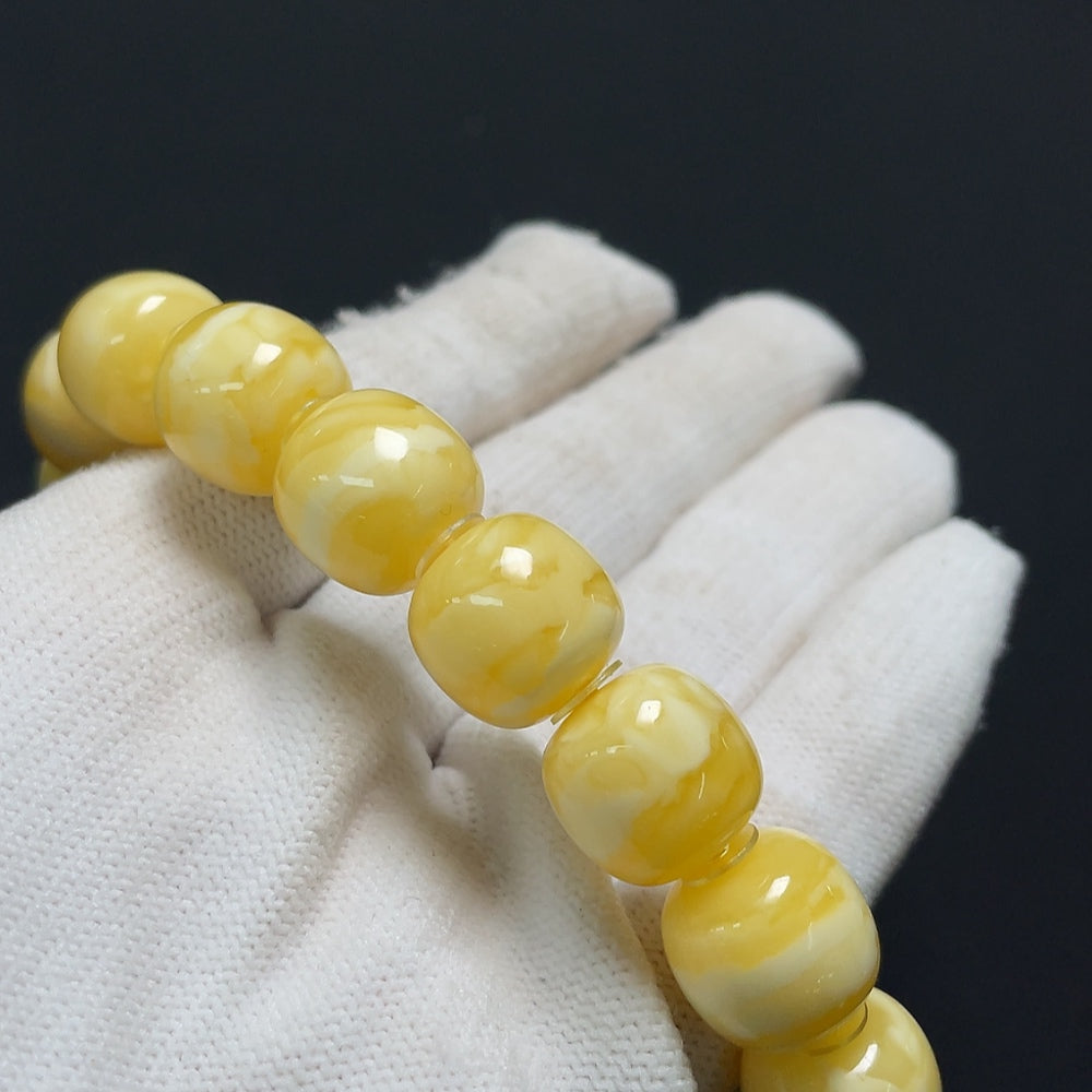 Amber Beeswax Bracelet by HKHQ featuring natural amber beads and a stretchable design on a neutral background.