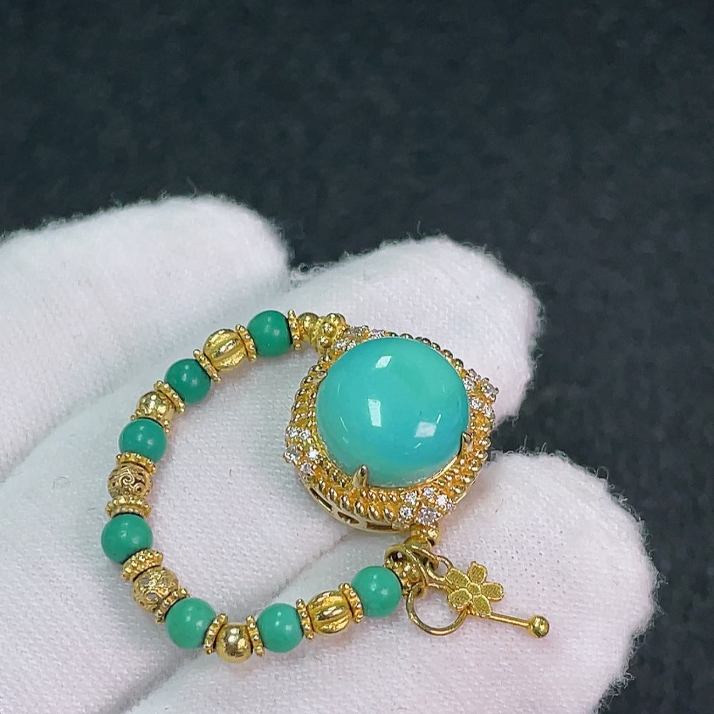 Close-up of turquoise gemstone jewelry featuring mineral components, gold content Au 66%, with 2.8-9.4mm stones, weight 3.88g.