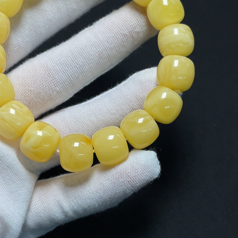 Amber beeswax bracelet by HKHQ featuring natural amber beads and a secure clasp on a plain background.