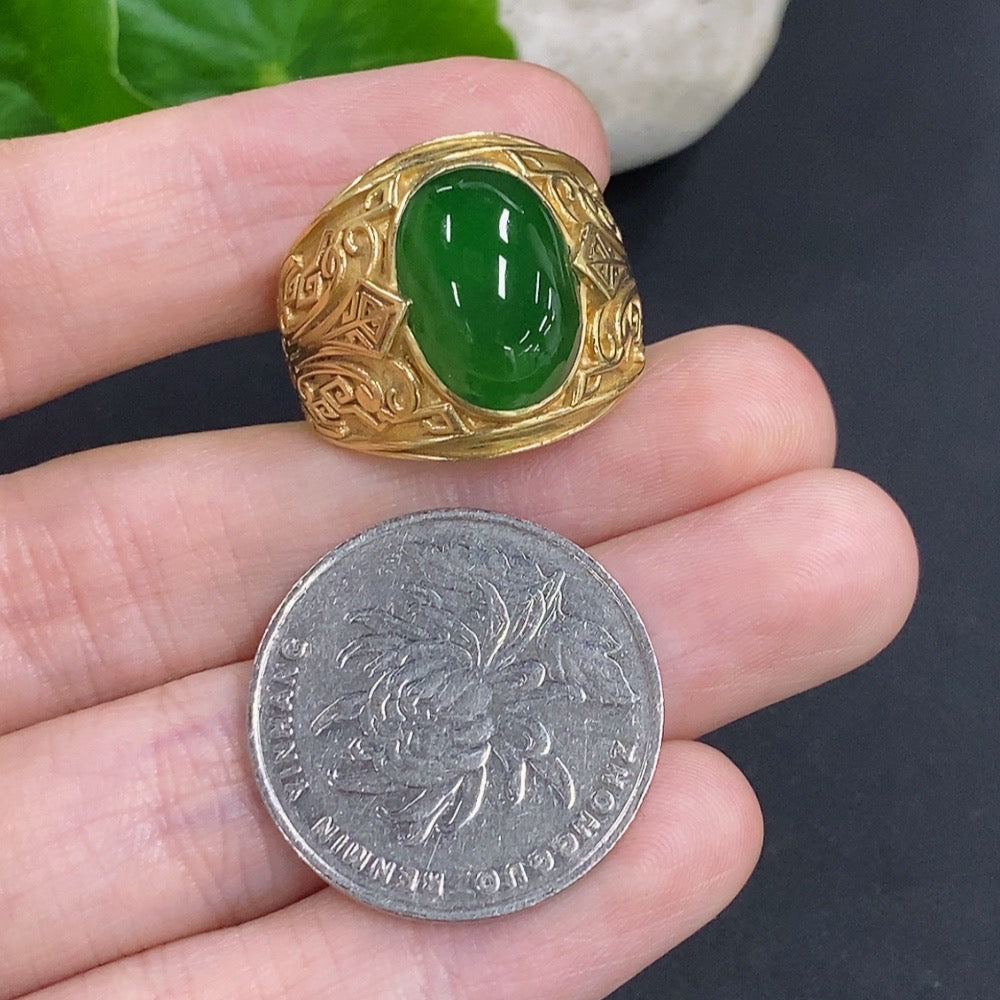 Elegant jadeite cabochon ring with 18K gold band, showcasing a polished green gemstone and intricate gold detailing.