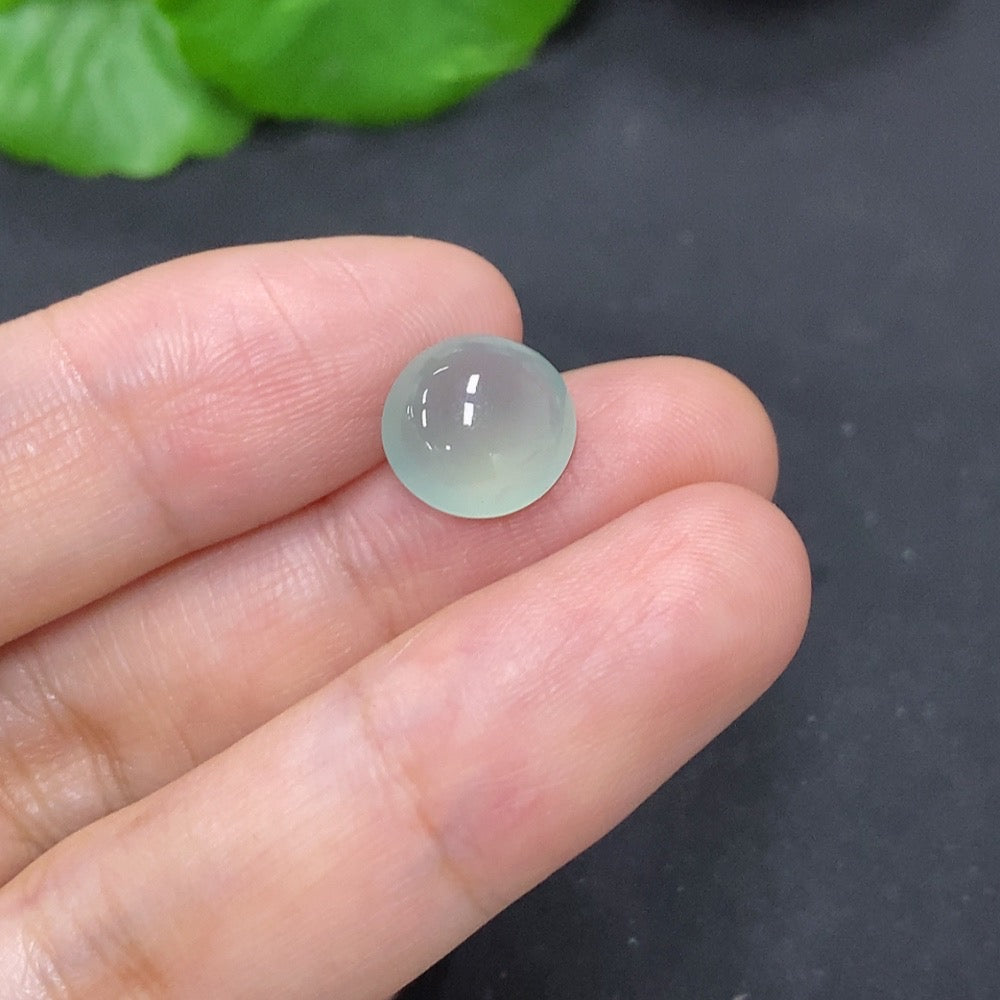 Small jadeite cabochon jewelry piece from HKHQ, showcasing smooth, polished green stone with natural translucence.