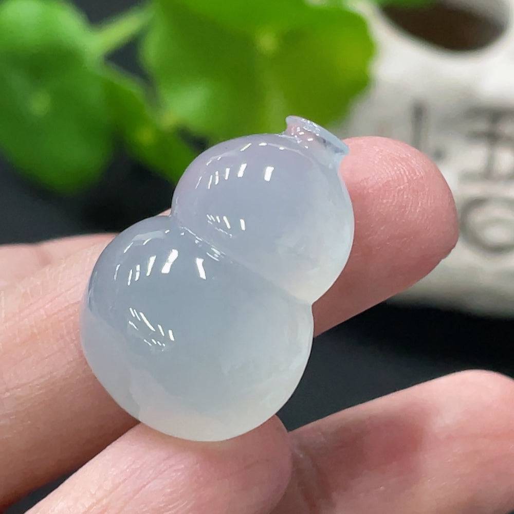 Jadeite gourd pendant with inlaid details from HUILIU HQ, weighing approximately 7.68 grams, displayed against a neutral background.