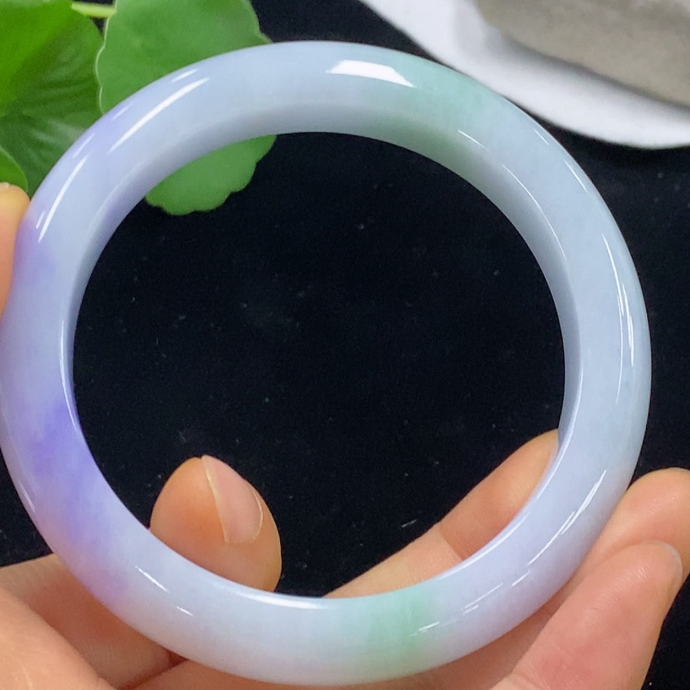 Jadeite bangle in size 59.3, weighing approximately 70.2g, featuring smooth, polished jade with natural green coloration.
