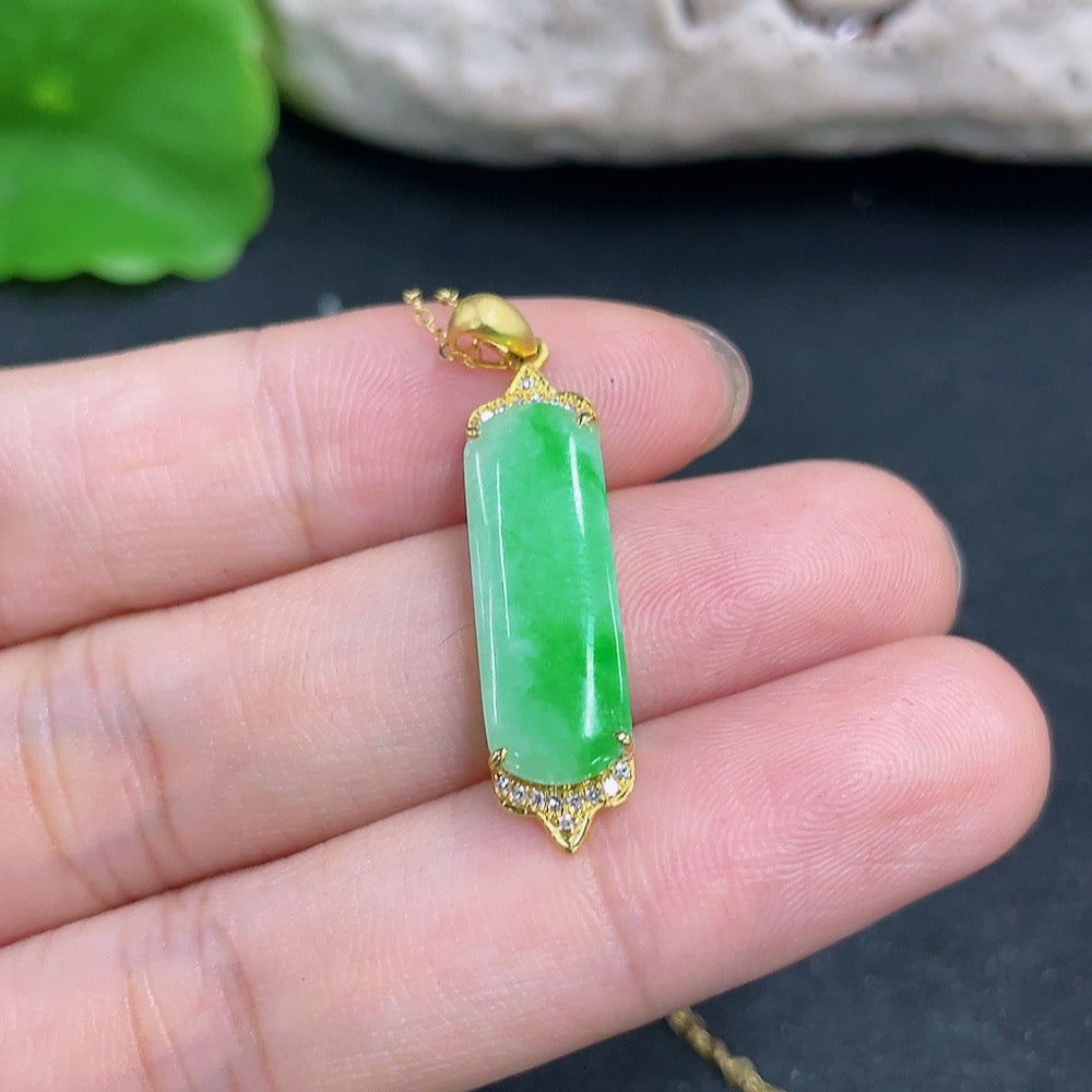 Jadeite pendant with 18K gold and diamond accents, featuring a polished green jade stone on a delicate necklace.