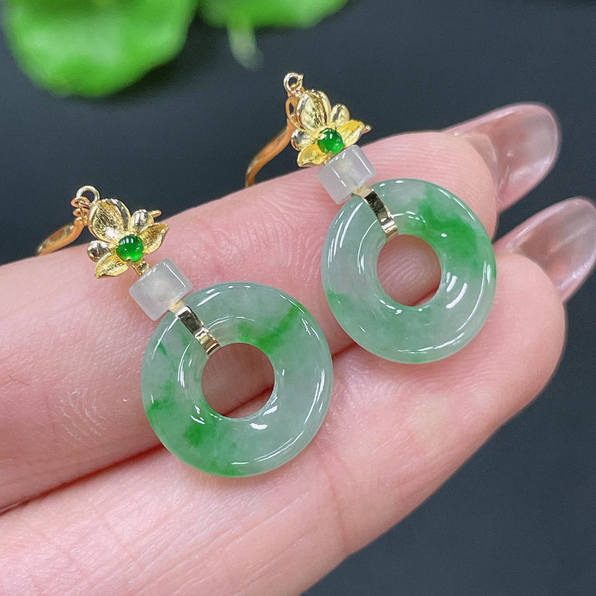 Huiliu Certified Jadeite earrings featuring smooth, polished jade stones with silver hooks on a white background.