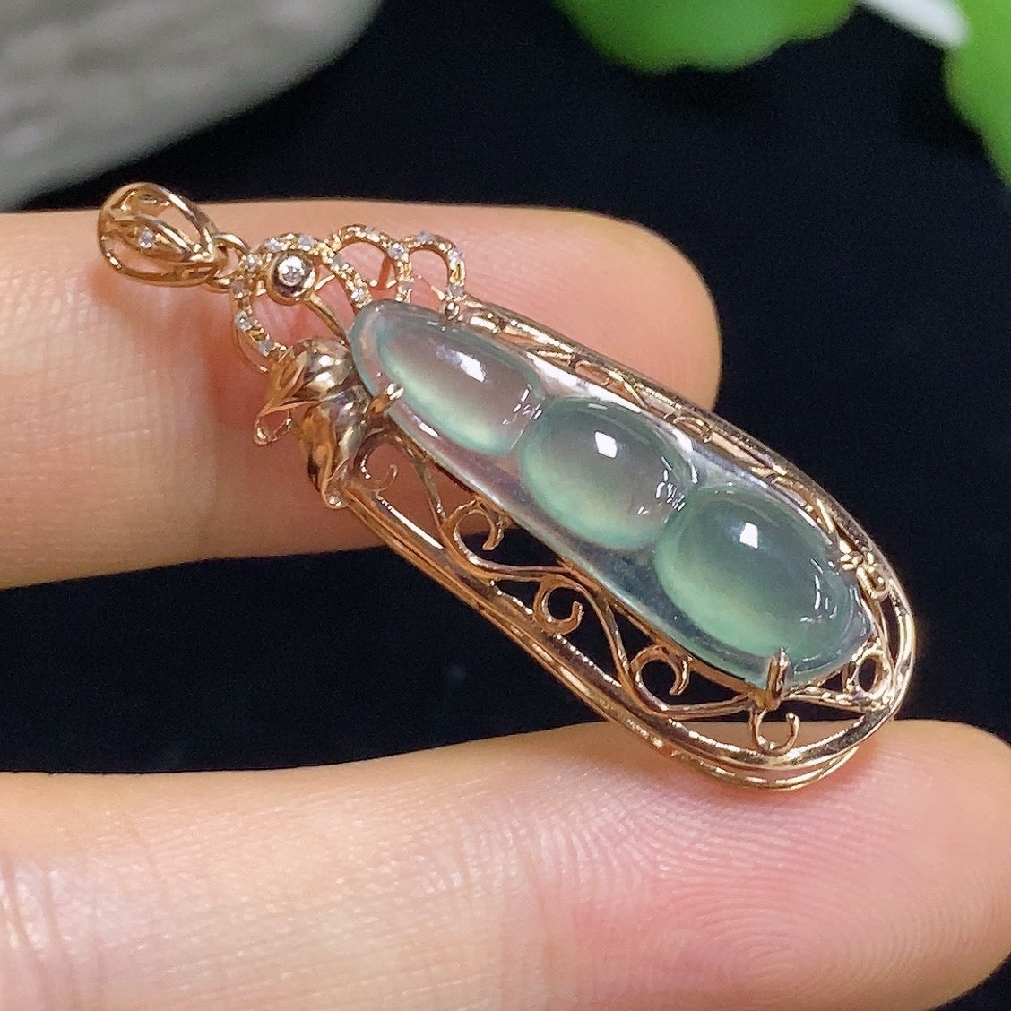 Jadeite auspicious bean pendant with 18K gold accents and diamond details, showcasing a smooth jade surface and intricate craftsmanship.