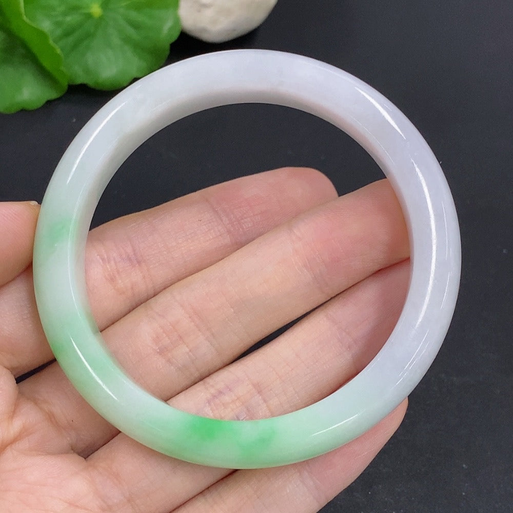 Jadeite round bracelet with mineral inclusions, weighing approximately 44g and size 55, displayed on a neutral background.