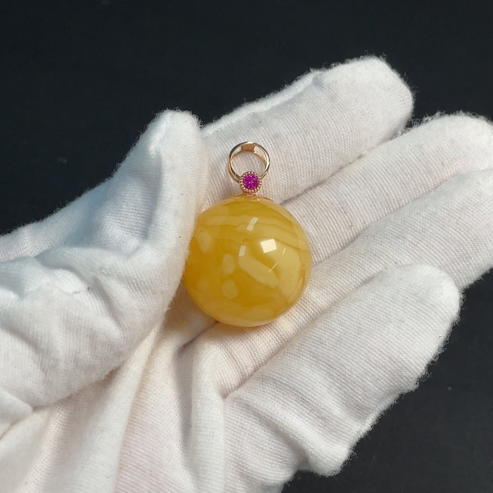 Amber beeswax pendant with 18K gold setting, featuring gemstone details, designed by HKHQ