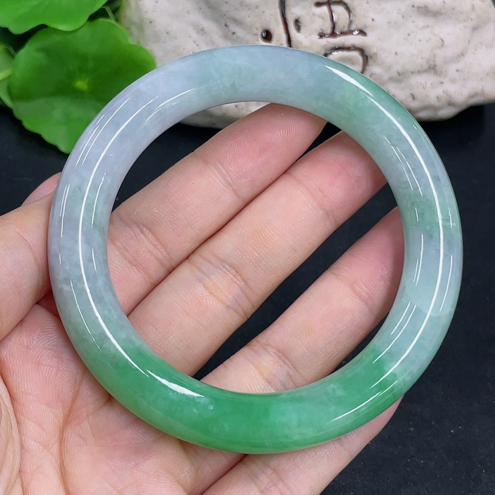 HKHQ jadeite round bangle with a 55.8mm size and 64.9g weight, smooth polished jade jewelry displayed on a neutral background.