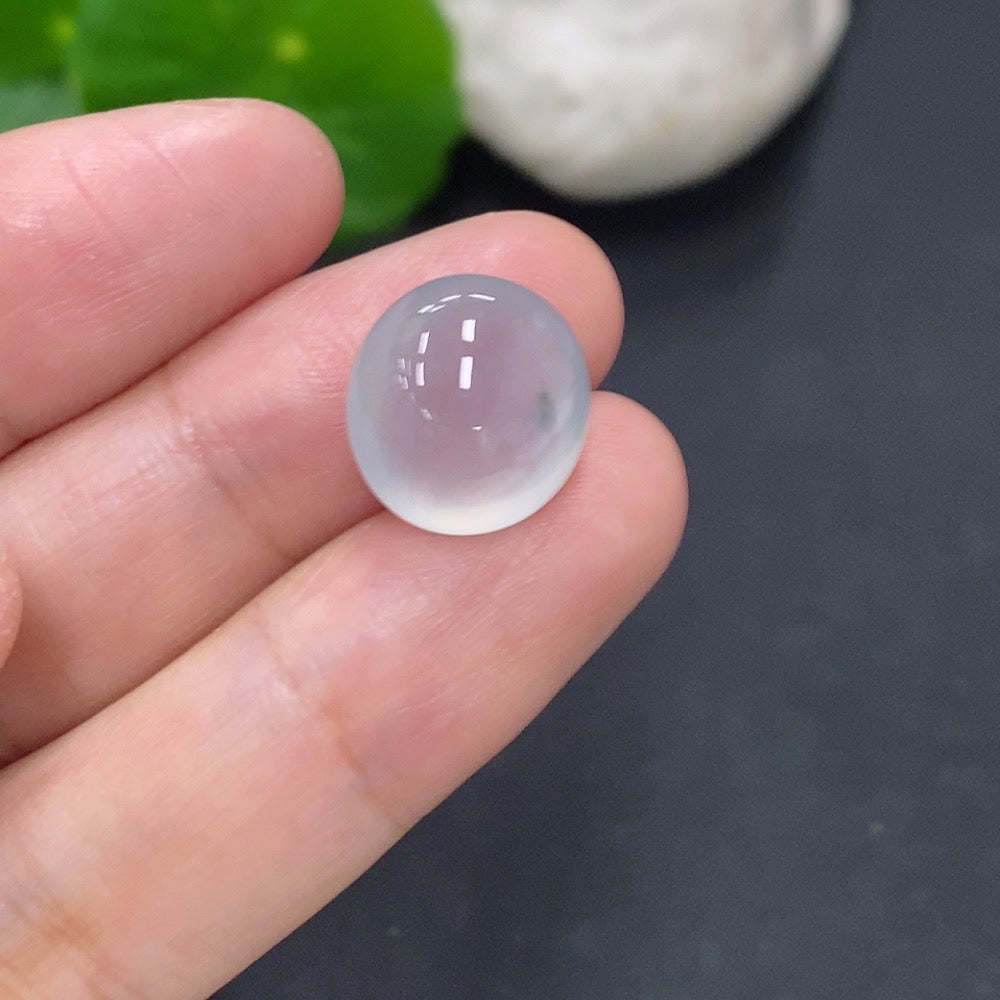 Jadeite cabochon jewelry piece from HKHQ, showcasing a smooth, polished green gemstone with natural variations and a glossy finish.