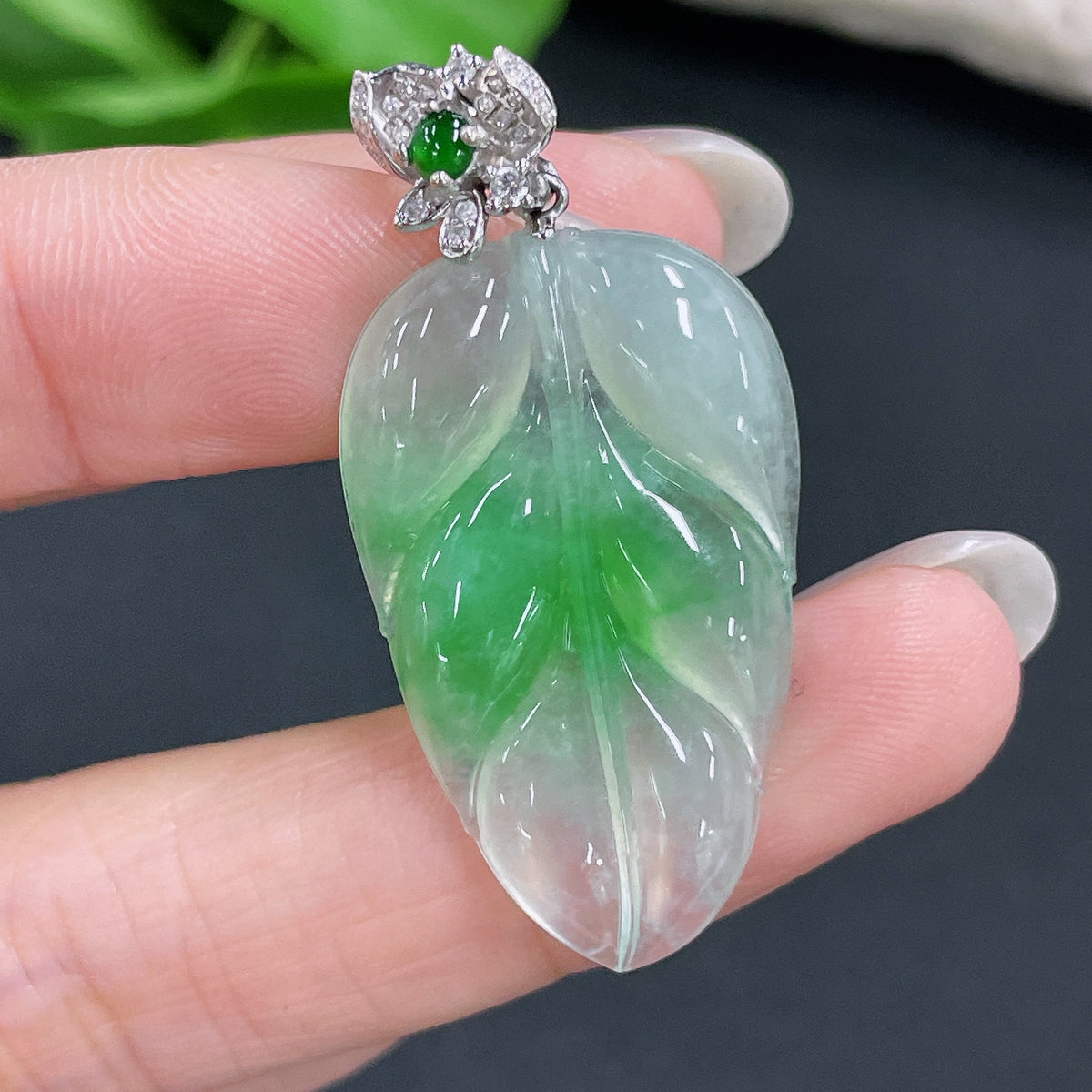 Jadeite pendant leaf with 18K bezel and diamond accents, set in HKHQ jewelry, showcasing detailed craftsmanship and elegant design.