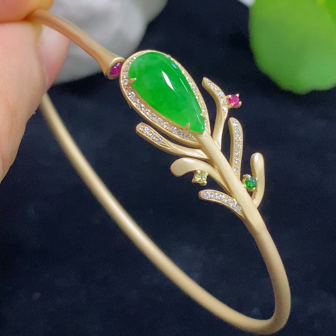 Jadeite bangle in 18K gold with colorless diamond accents, elegant bracelet featuring smooth jadeite and sparkling gemstones.