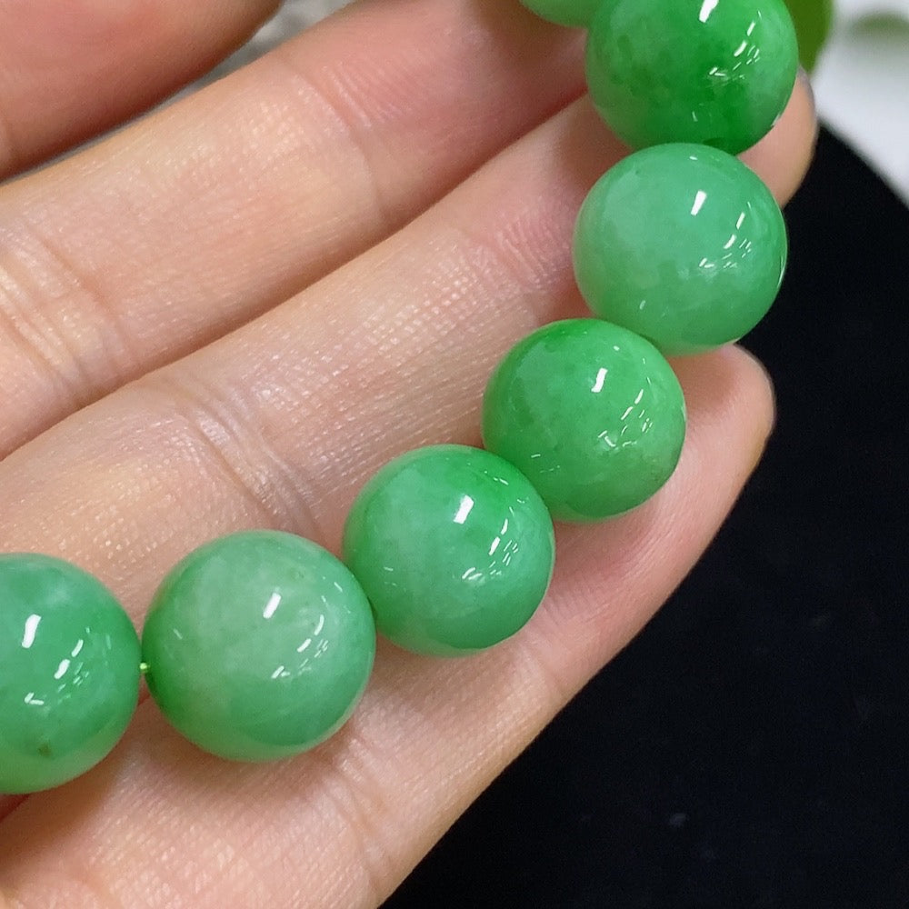Jadeite bracelet with 11mm beads, handcrafted jade jewelry by HKHQ, showing close-up of smooth, polished green jade beads.