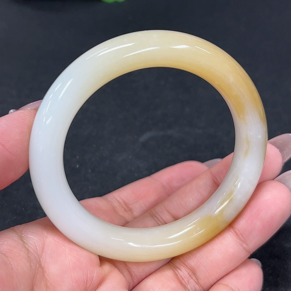 HKHQ Hetian Jade round bangle with mineral components, size 54.9, weighing approximately 54.9g, showcasing smooth jade craftsmanship.