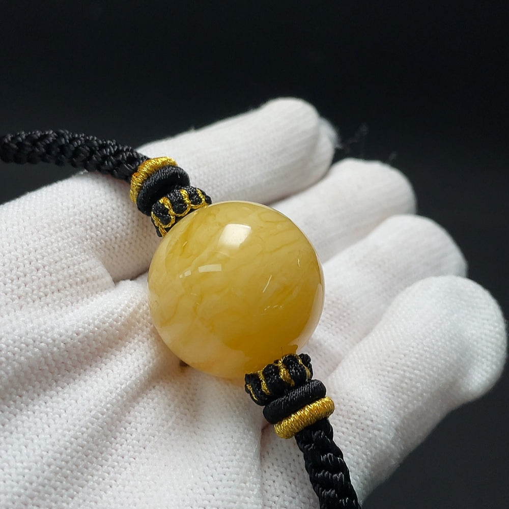 Amber beeswax pendant necklace with cord, approximately 25.2mm in size, from HKHQ featuring a warm, natural beeswax design.
