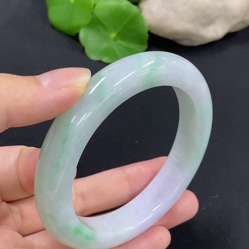 HKHQ jadeite round bangle in size 58.9 with a polished surface, weighing 76.08g, showing its smooth, rounded design.