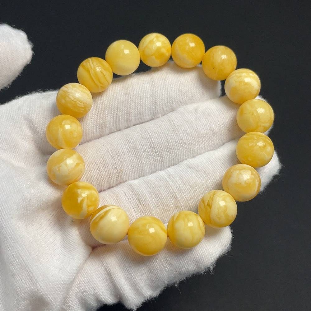 Amber beeswax bracelet with 11.4mm beads, weighing 13.48g, showcasing warm amber tones and smooth, polished surface.