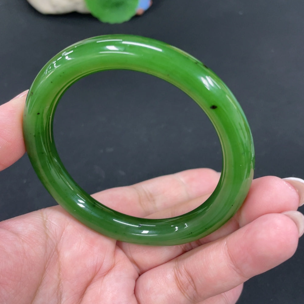 Huiliu Certified Hetian Jade round bangle showcasing smooth, polished green jade with natural stone patterns.