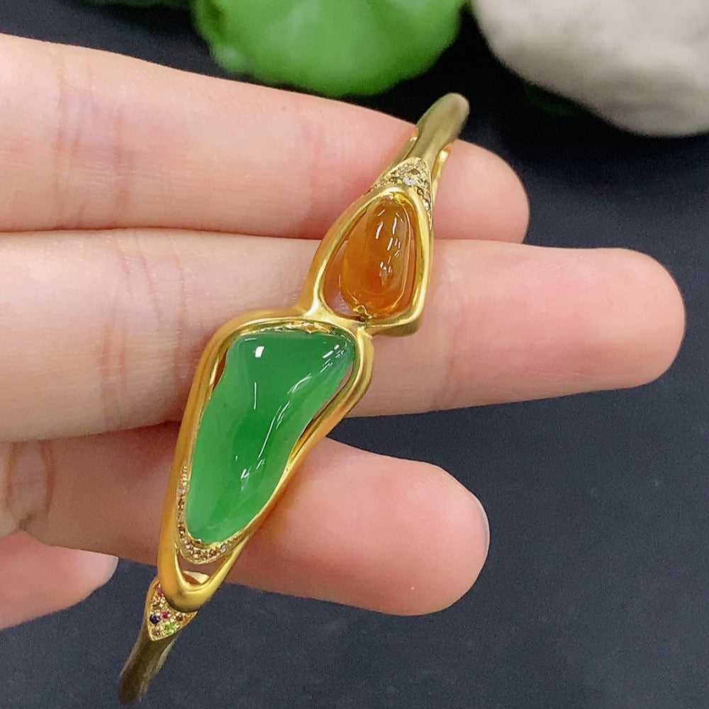 Jadeite inlaid bangle with diamond accents, 18k gold, showing detailed craftsmanship and a smooth, polished surface.