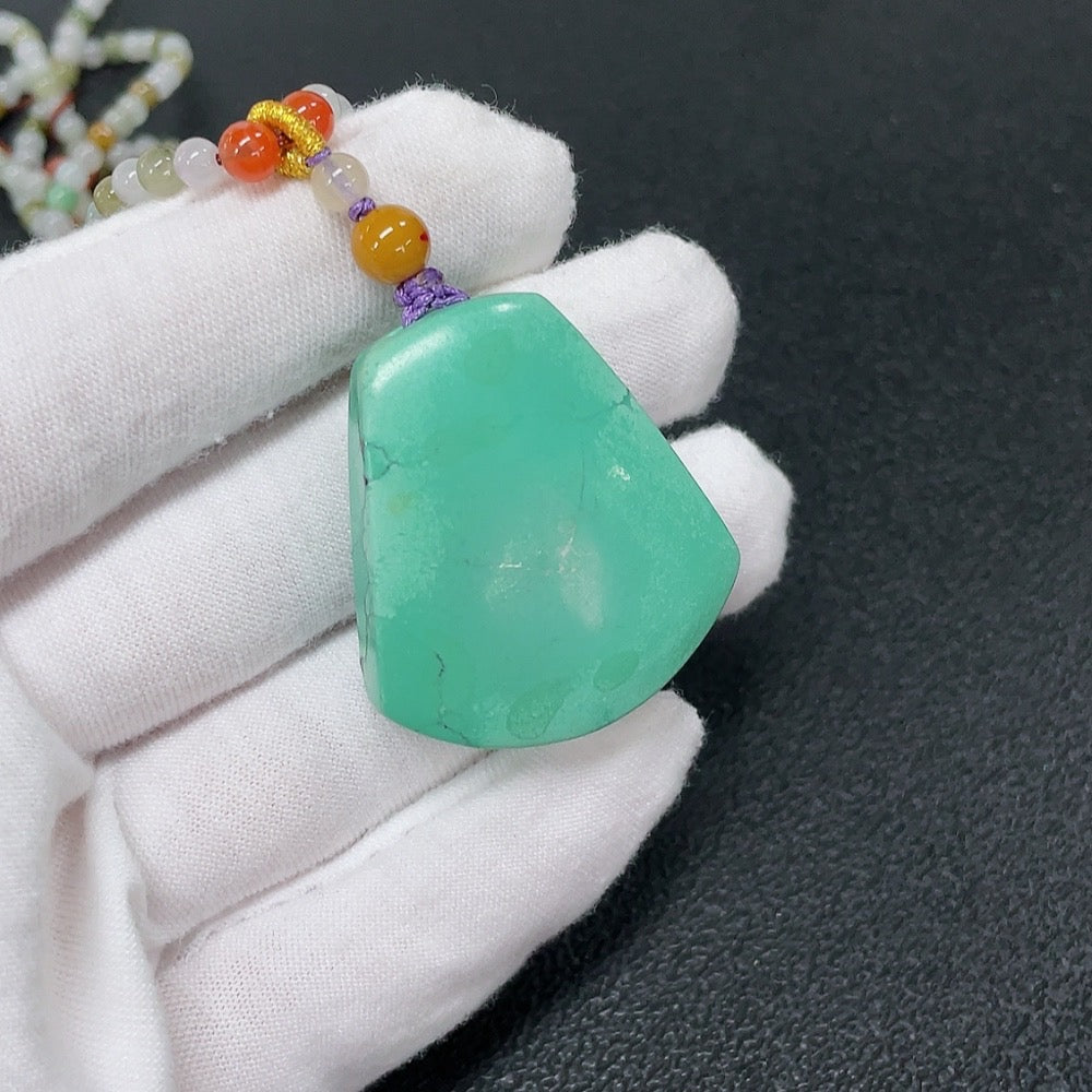Turquoise gemstone pendant with Southern Red Agate, featuring mineral components and a cord, crafted by HKHQ.