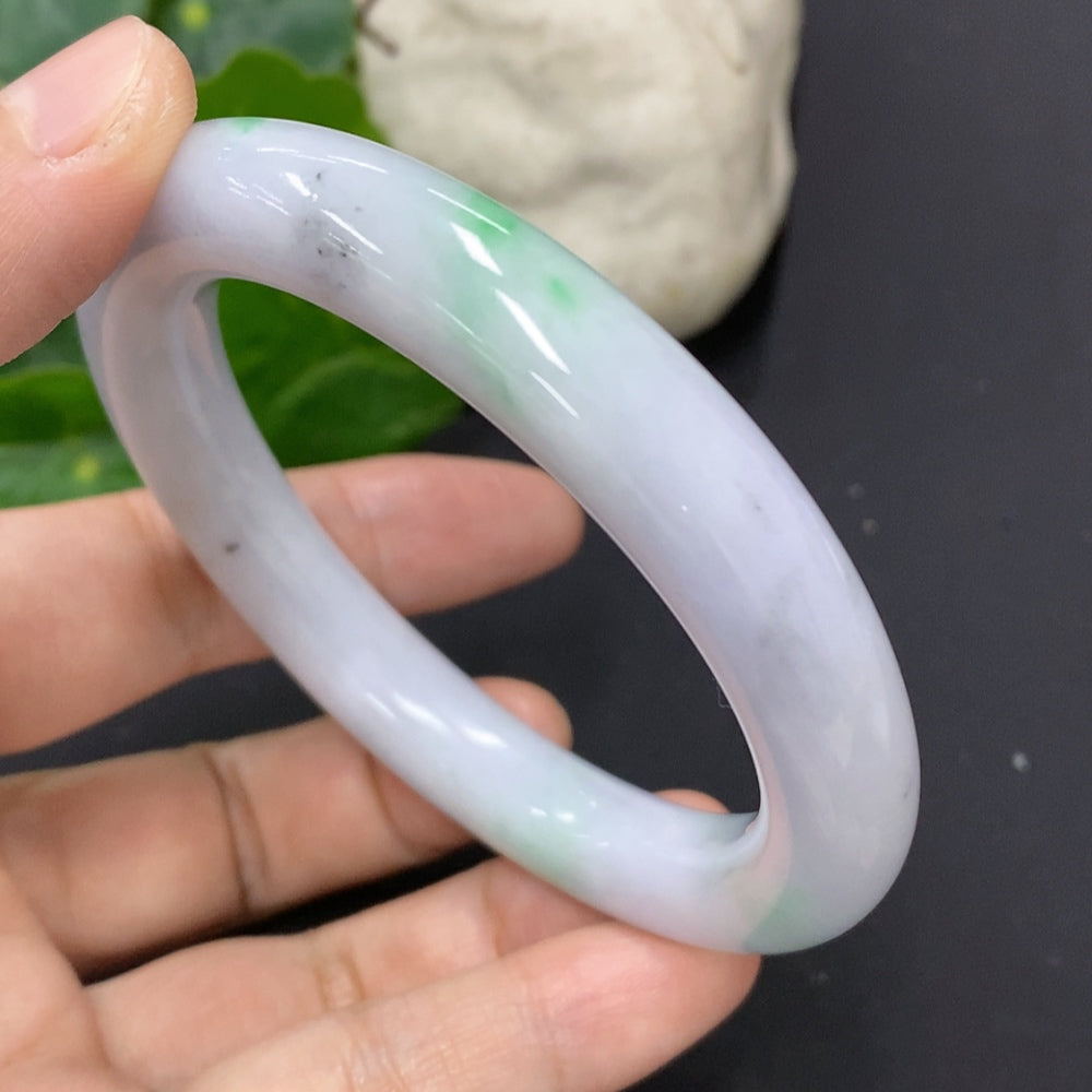 HKHQ jadeite round bangle with colorful polishing powder, size 56.8, showcasing smooth jade surface and vibrant finish.