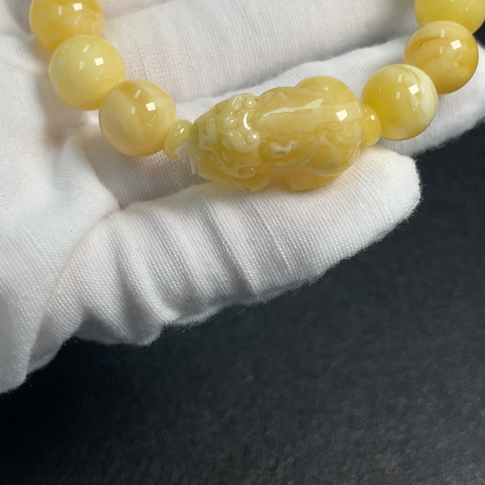 Amber and beeswax bracelet with 11.1-14.2mm amber beads, weighing approximately 14g, featuring natural warm tones and smooth texture.