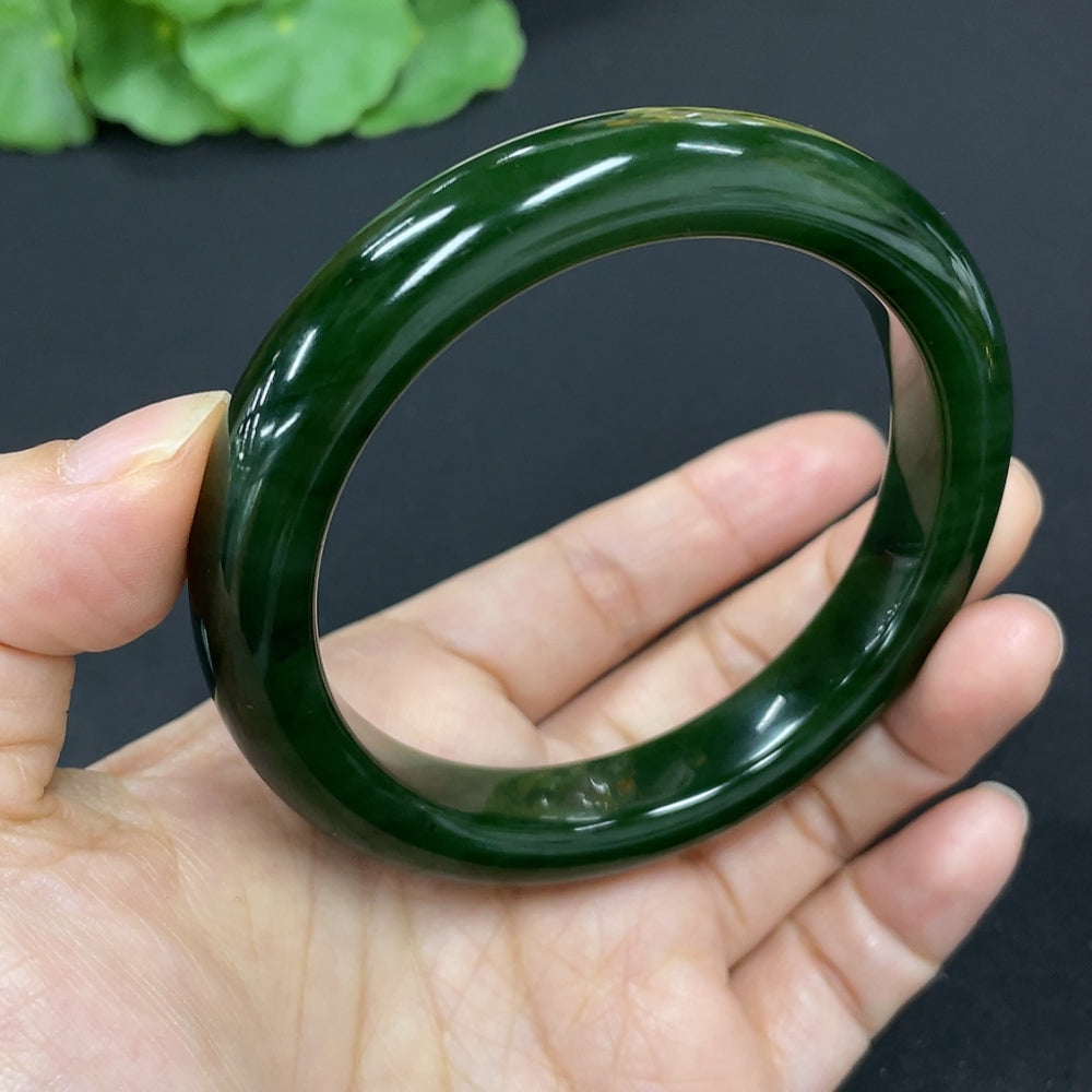 Green Hetian Jade round bangle bracelet from HKHQ, showcasing smooth, polished jade with a natural green hue.