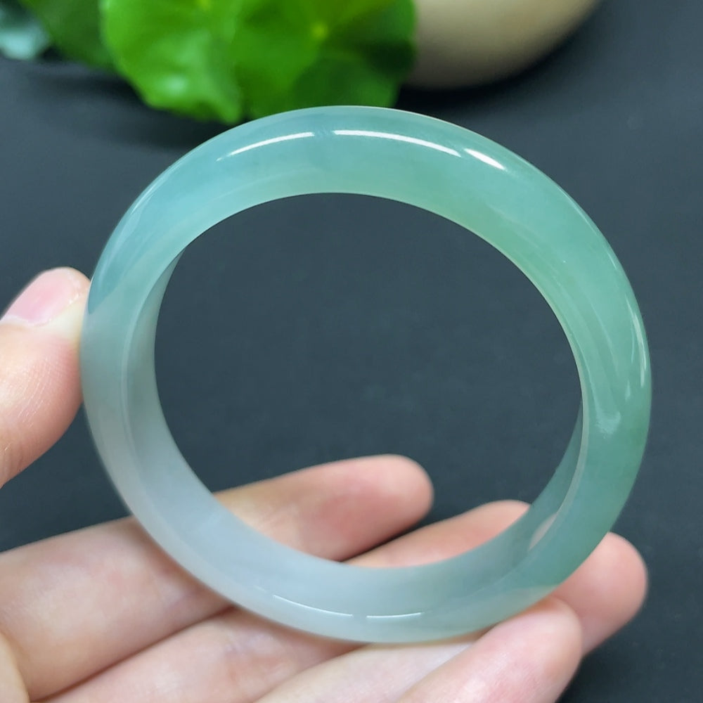 Jadeite oval bangle bracelet in size 55.6, weighing 35.37g, crafted by HKHQ, featuring smooth, polished jadeite surface.