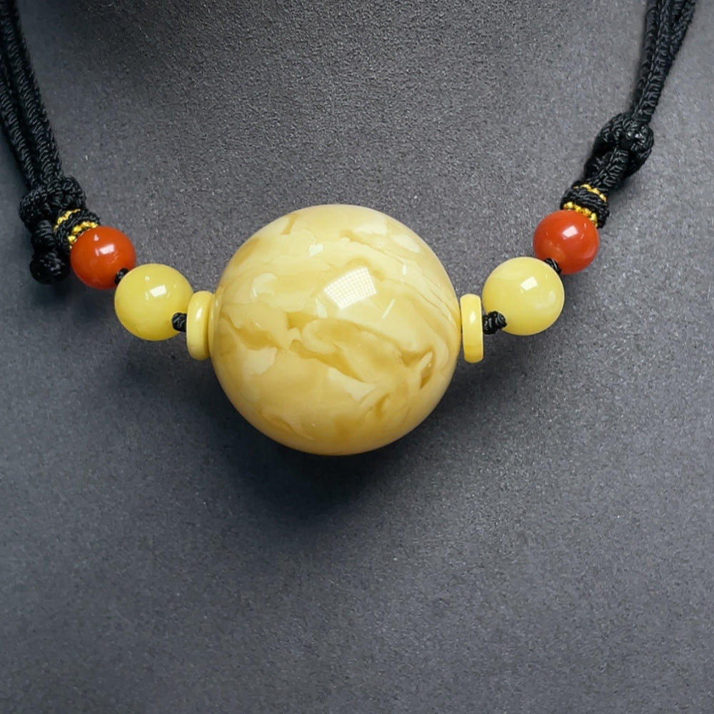 Huiliu Amber Beeswax Pendant with Southern Red Agate, 33mm, featuring a rope necklace and certified craftsmanship.
