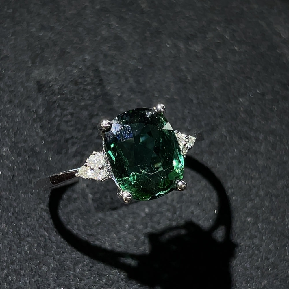 Tourmaline ring with gold setting and diamond accents, featuring a vibrant green gemstone and elegant design by HKHQ.
