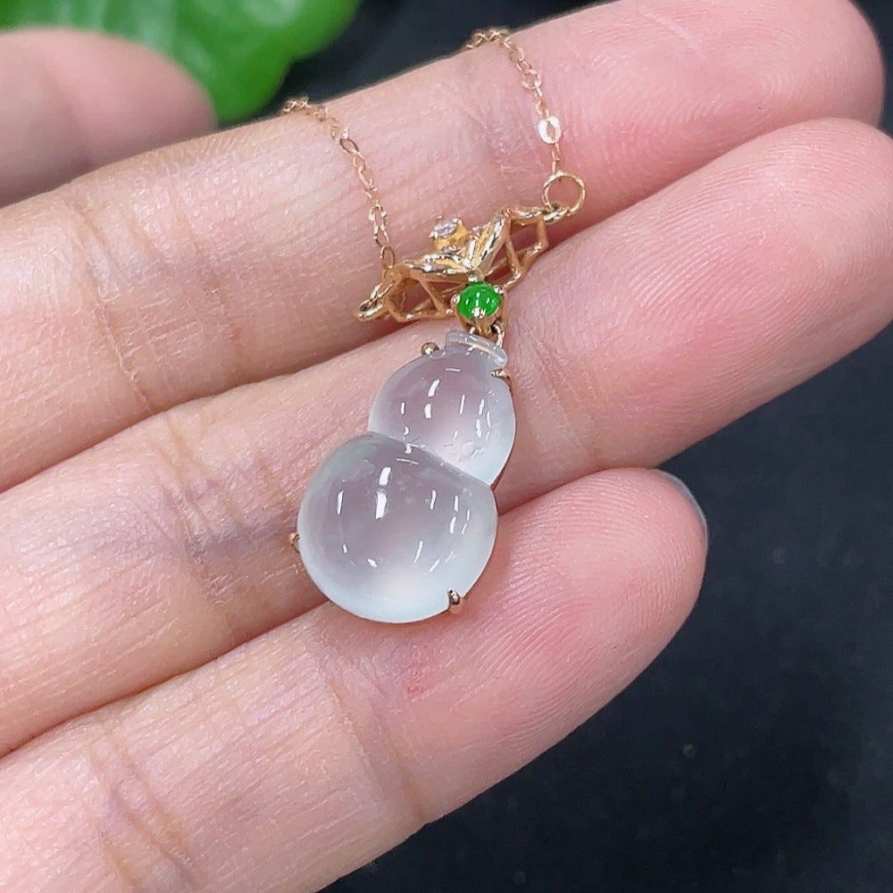 Jadeite inlaid gourd pendant with 18K gold and diamond accents, showcased on a necklace chain.