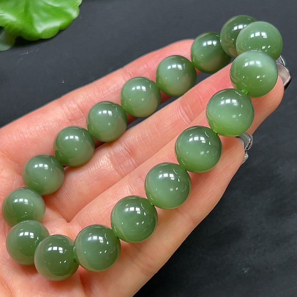 HKHQ Hetian Jade bracelet with 11.8mm beads, showcasing smooth, polished green jade stones on a delicate bracelet.