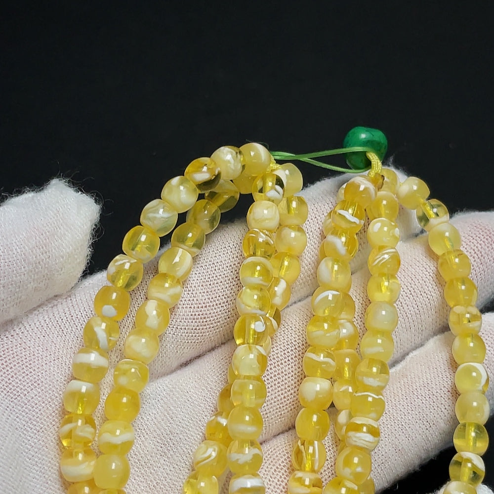 Amber HKHQ beeswax bead strand with 5.5mm amber beads and non-natural accent stones, total weight approx. 14.32g.