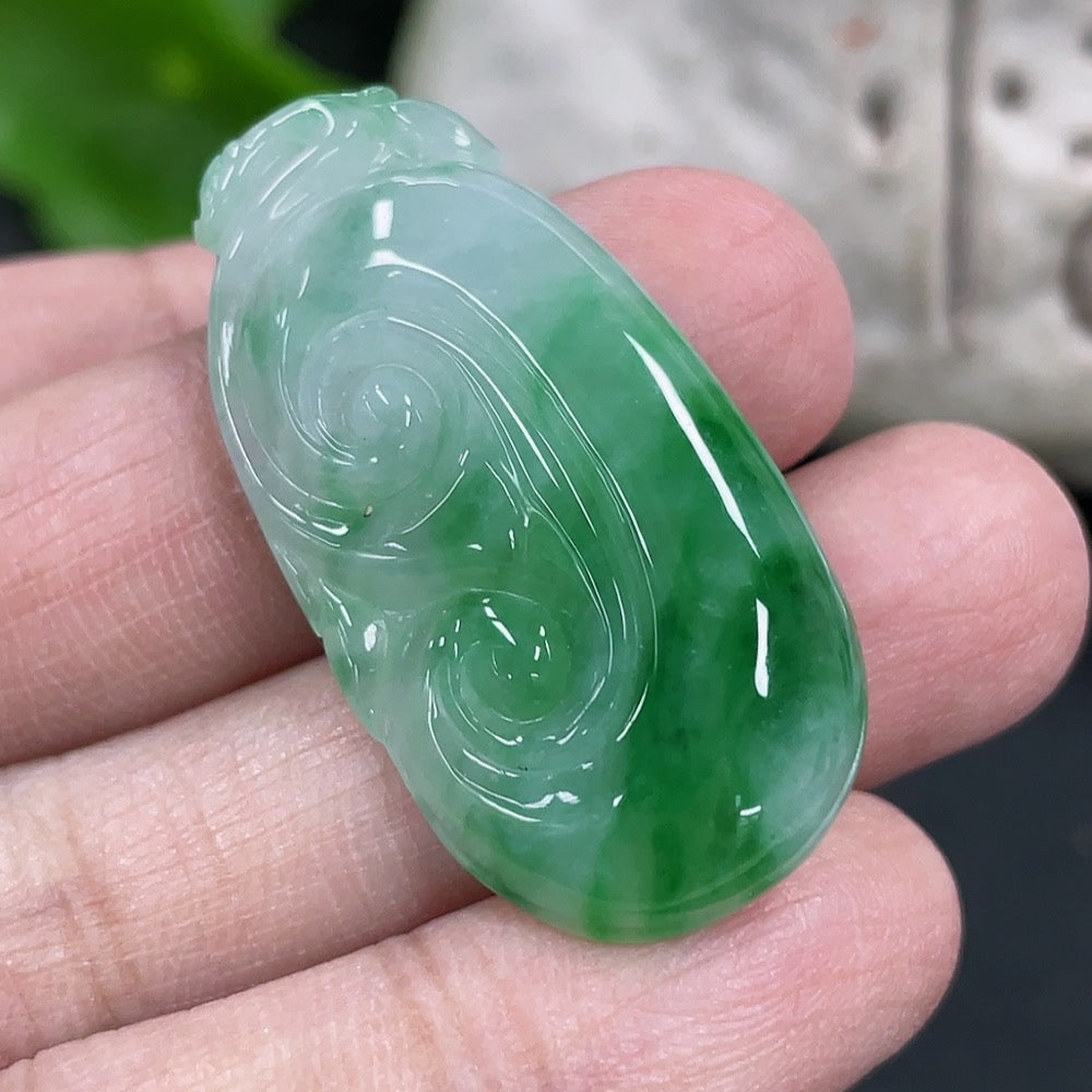 Jadeite Ruyi pendant necklace with intricate carvings, featuring a smooth green jadeite stone on a delicate chain.