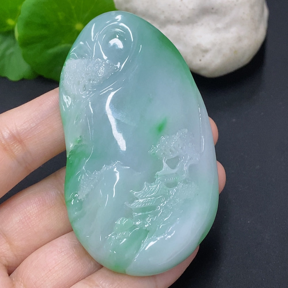 Jadeite landscape pendant from HKHQ showcasing intricate jade carving with natural green and white hues, approximately 65.3 grams.